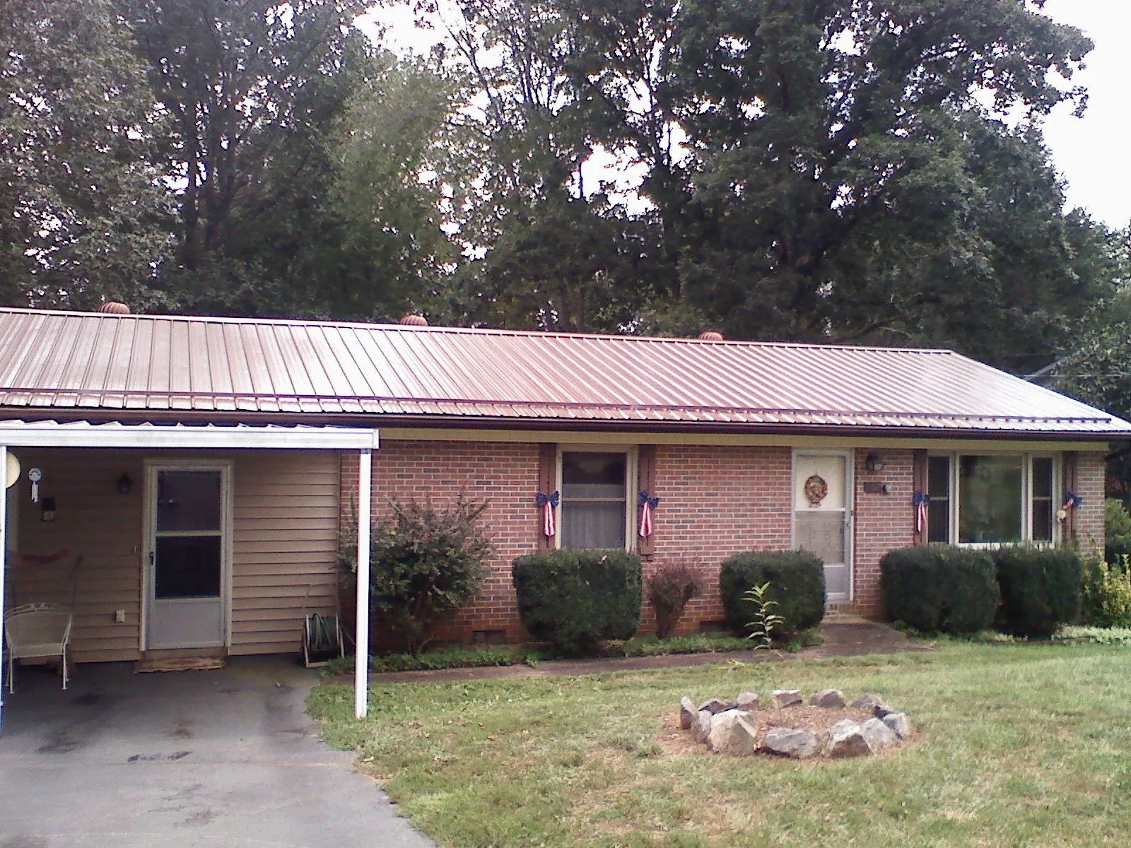 Bronze metal roof and carport on a brick ranch home — Roof Repair work by our crew in Pontotoc