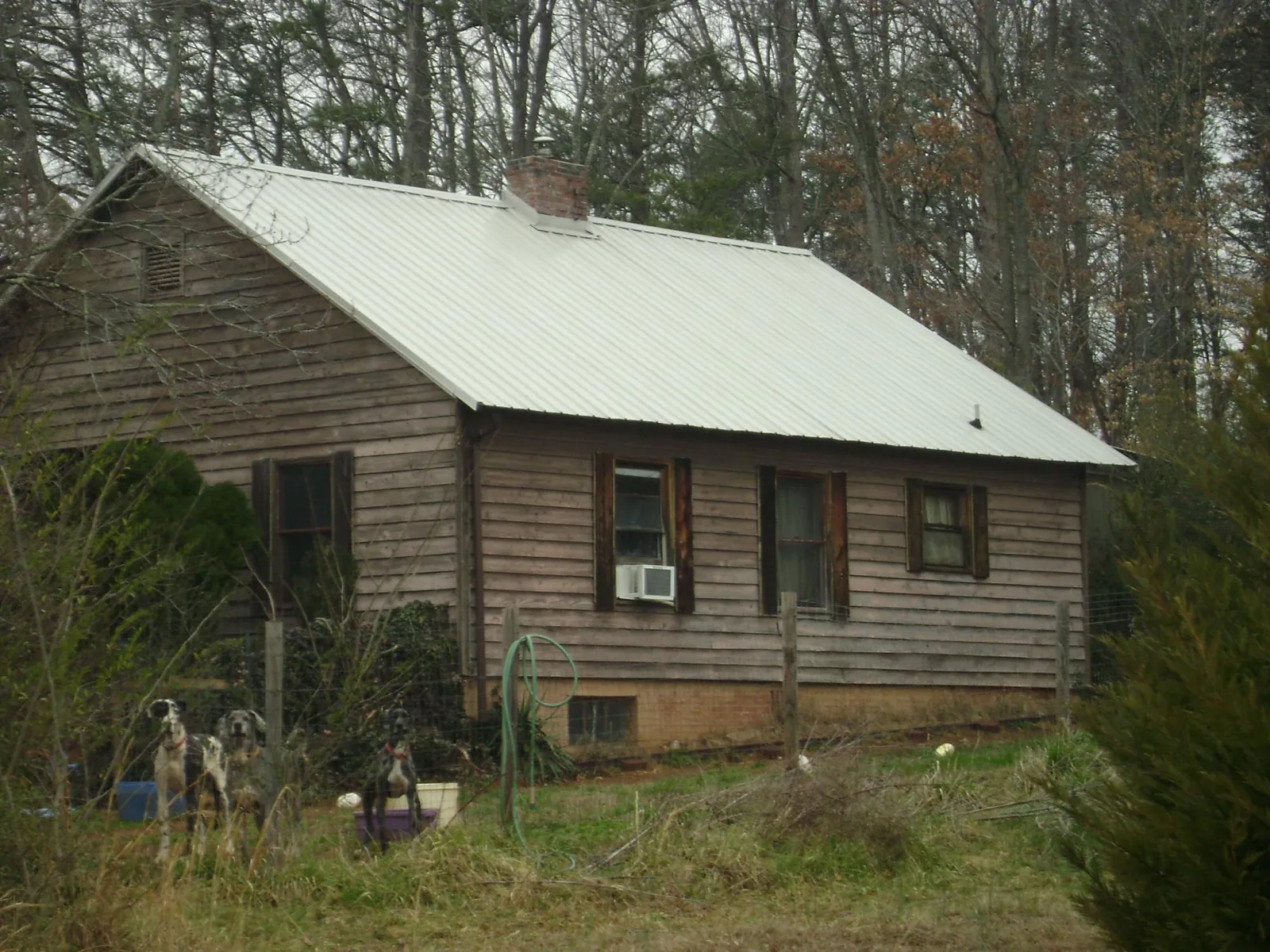 White metal roof on an old wood sided farmhouse, from a Metal Roof Installation job in Pontotoc